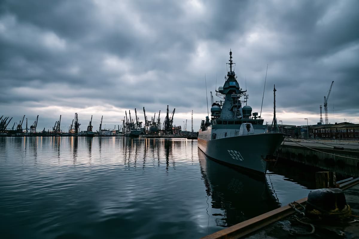Серая военно-морская верфь под пасмурным небом, создающая впечатление инвестиций в оборонную промышленность.